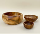 Three handcrafted wooden bowls of different sizes with rich natural grain patterns