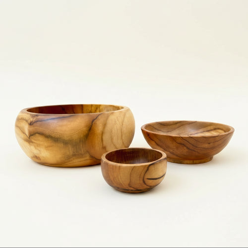 Three handcrafted olive wood bowls of different sizes 
