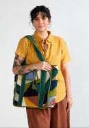 Woman holding a colorful patchwork bag against a white background