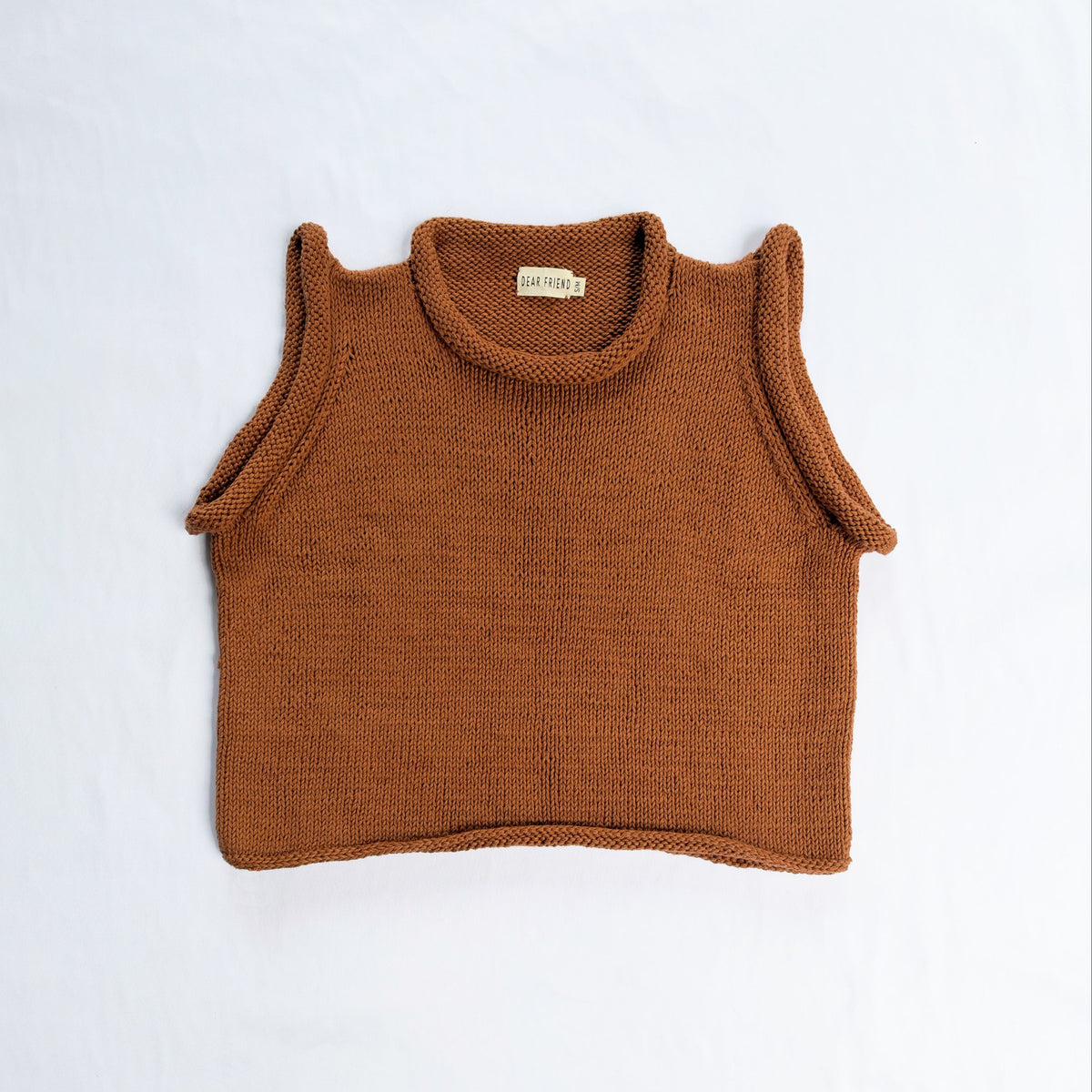 A brown knit sleeveless crop top with a roll neck, laid flat on a white background.