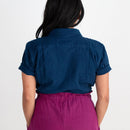 Person wearing a blue shirt and purple pants on a white background