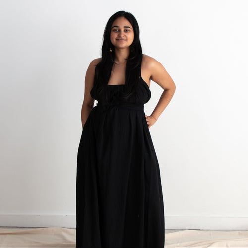 Woman wearing a black dress standing against a white background