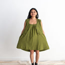 Woman wearing a green sleeveless dress on a white background