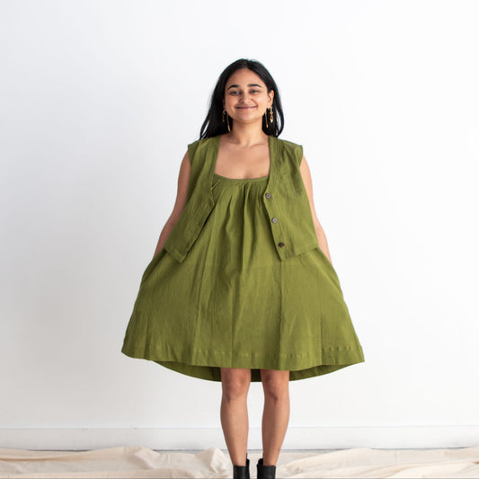 Woman wearing a green sleeveless dress on a white background