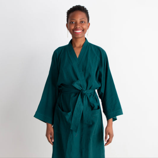 Woman wearing a teal robe against a white background