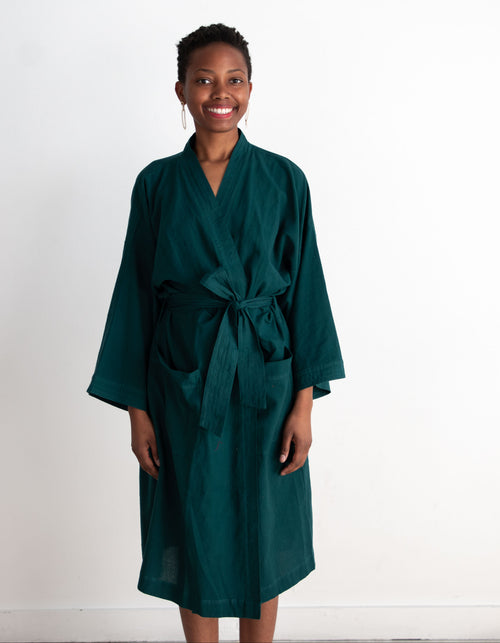 Woman wearing a teal robe against a white background