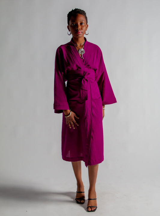 Woman wearing a magenta robe against a plain background