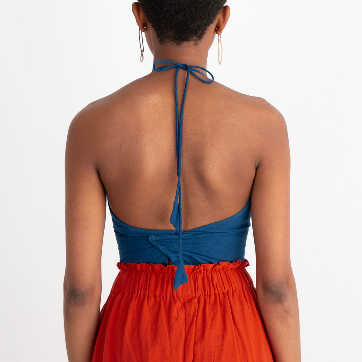 Woman wearing a blue top and red dress on a white background