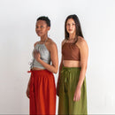 Two women standing side by side wearing colorful outfits on a white background