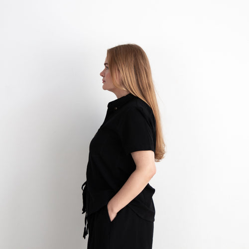 Woman wearing a black outfit against a white background