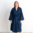 Woman wearing a navy blue robe against a white background