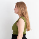 Woman wearing a green top and black skirt on a white background