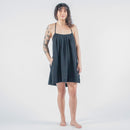 Woman wearing a black dress standing on a white floor 