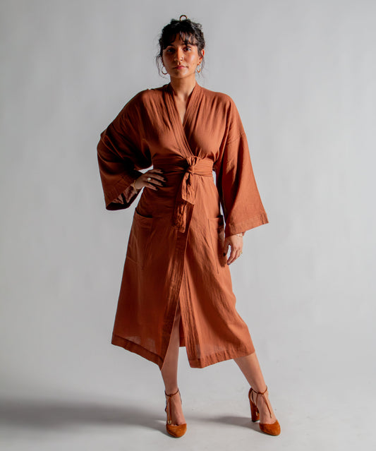 Woman wearing a brown dress against a plain background