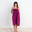 Woman wearing a purple dress standing against a white background