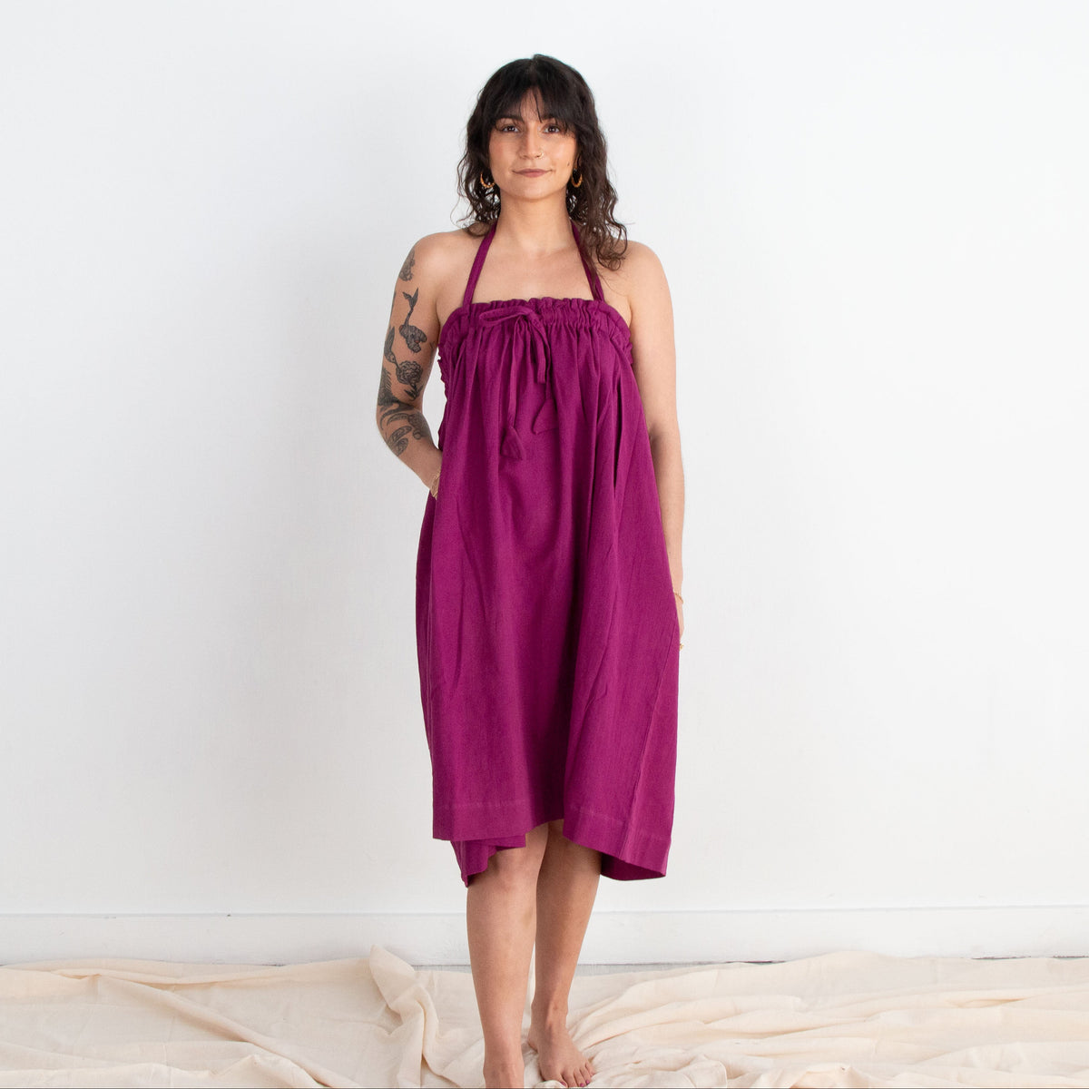 Woman wearing a purple dress standing against a white background