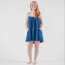 Woman wearing a blue dress standing on a white background 