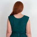 Teal top worn by a person on a plain background