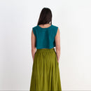 Woman wearing a teal top and green skirt on a white background