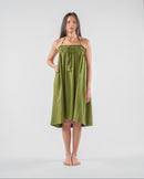 Woman wearing a green dress standing on a white background 