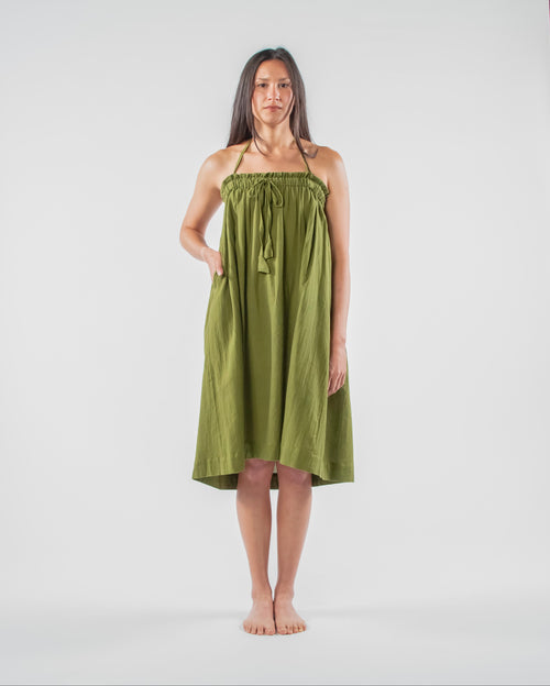 Woman wearing a green dress standing on a white background 