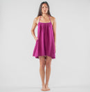 Woman wearing a purple dress standing in a studio setting 