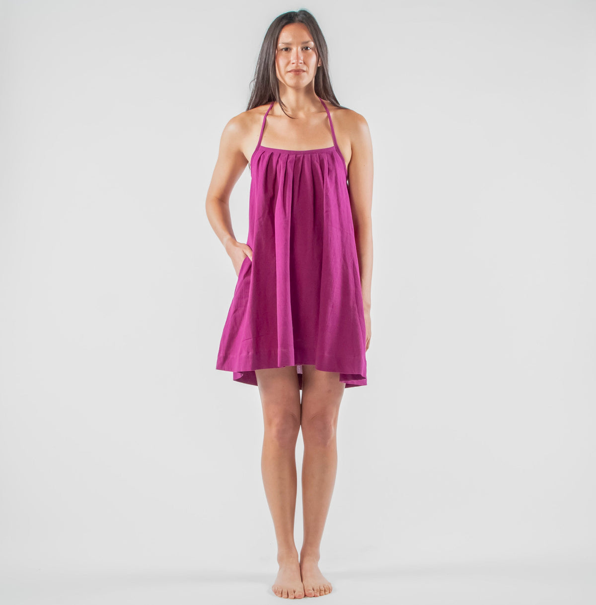 Woman wearing a purple dress standing in a studio setting 