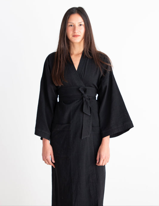 Woman wearing a black robe against a white background