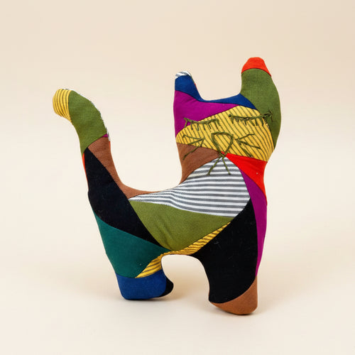 A handmade patchwork fabric cat toy that features multiple colorful fabric panels in green, black, yellow, purple, red, blue, and brown.