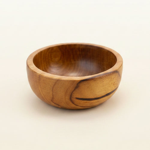 A small handcrafted wooden bowl with a warm honey-brown finish and visible wood grain